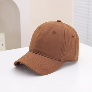 Detailed close-up of brown cotton baseball cap stitching and breathable eyelets