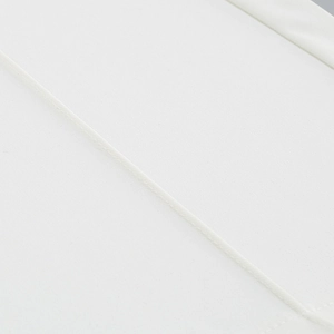 Detailed close-up of white fabric texture and precision stitching on women suit trousers