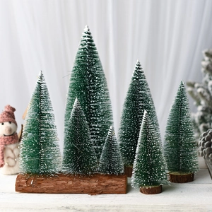 Miniature cedar Christmas trees with white snow powder and natural wooden bases