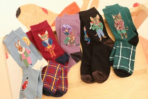 Detail of five assorted forest animal jacquard cotton socks on a wooden surface