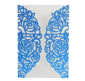 Macro shot of blue glitter paper with laser-cut rose patterns on elegant wedding invitation
