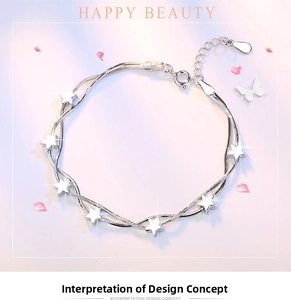 Detail of silver triple snake chain bracelet featuring five-pointed star charms