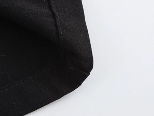 Detailed close-up of stitching and fabric texture on a black sleeveless jumpsuit