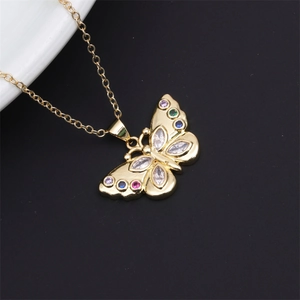 Detail of gold butterfly pendant with colorful zircons on a delicate chain necklace