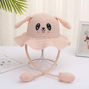 Close-up of pink and beige kids straw hats featuring movable bunny ears for summer sun