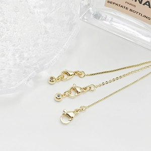 Detail of adjustable 14k gold-plated chains with lobster clasps and evil eye beads