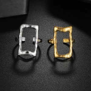 Macro detail of irregular gold and silver adjustable rings on a black textured background