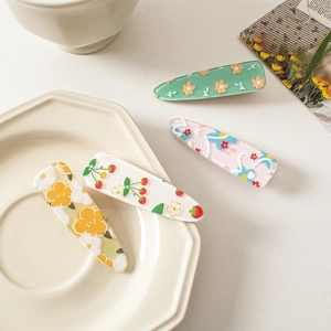 Close-up of cute floral acrylic hair clips with cherry and flower patterns in a set