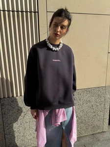 Detail of dark gray oversized sweatshirt featuring white letter print and crew neck