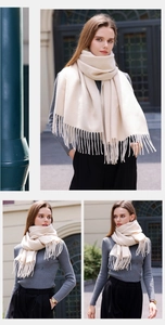 Detail of soft beige cashmere-feel scarf with elegant tassels on urban street