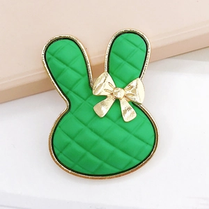 Detail of green rabbit charm with quilted texture and gold metallic bow detail