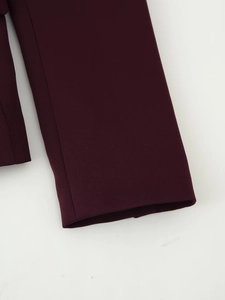 Detailaufnahme der Nähte und Stofftextur am Ärmel eines burgunderroten Blazers