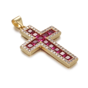 Close-up of golden cross pendant with red square gemstone and white zirconia stones