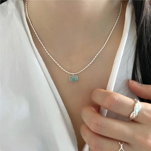 Elegant 925 sterling silver necklace with green rectangular pendant on a model