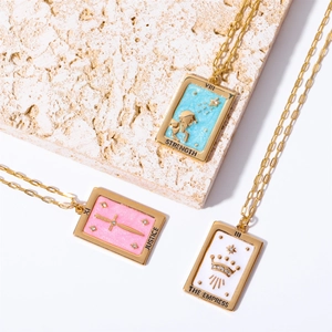 Close-up of gold tarot card necklaces featuring Strength, Justice and The Empress pendants