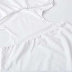 Gros plan d'une robe en maille blanche avec détails ajourés et texture de tissu froncé