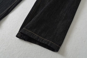 Dettaglio dell'orlo a doppia cucitura e della trama denim spessa di questi jeans