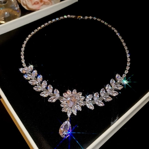Detailed close-up of zircon leaf and flower necklace with teardrop pendant in gift box