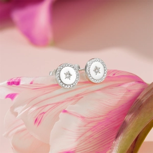 Close-up of a silver 925 stud earring with a star pattern on delicate flower petals