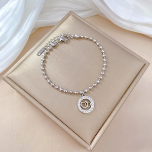 Macro view of silver titanium steel bead bracelet with sparkling zircon heart pendant