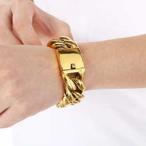 Nahaufnahme eines hochglanzpolierten goldenen Panzerarmbands im Hip-Hop-Stil am Handgelenk