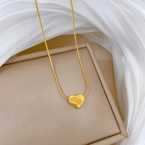 Elegant gold heart pendant on a fine snake chain resting on a premium jewelry box