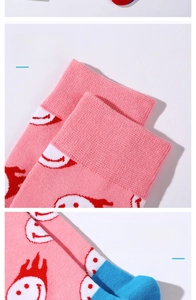 Detail view of pink cotton crew socks featuring smiley patterns and elastic non-slip cuffs
