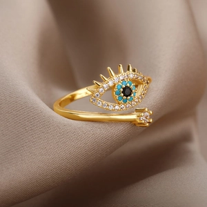 Detailed view of evil eye open ring with blue stones and crystals on silk fabric