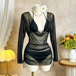 Detail of black mesh beach cover-up featuring side drawstrings and deep V-neckline texture