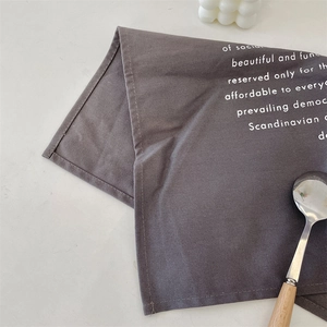 Close-up of grey Scandinavian fabric napkin with white text and canvas weave texture