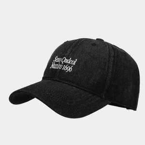 Close-up of vintage black denim baseball cap with white letter embroidery details