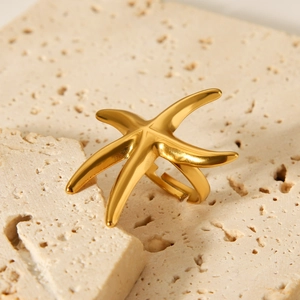 Minimalist gold starfish open ring in stainless steel on a natural stone surface