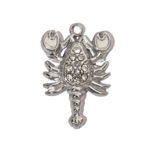 Detailed view of a silver scorpion pendant with inlaid crystals and a polished metal finish