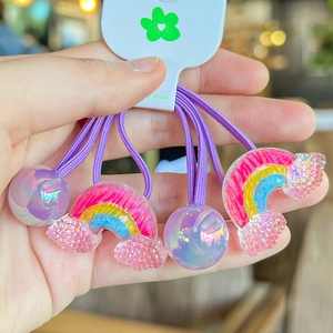 Dettaglio di elastici per capelli viola con perle iridescenti e ciondoli arcobaleno