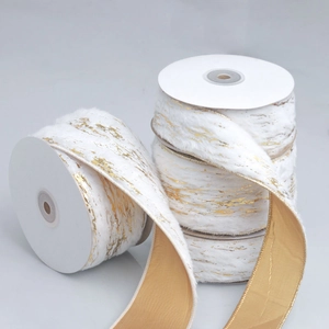 Detail of white faux rabbit fur ribbon with gold foil patterns and champagne backing