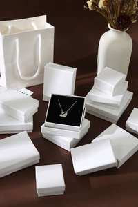 Elegant swan pendant necklace with white crystals on gold chain inside jewelry box