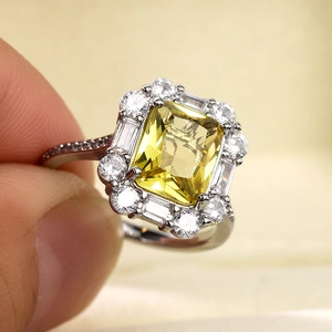 Macro detail of luxury ring featuring a large rectangular yellow gemstone and side diamonds