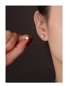 Close-up of S925 silver star stud earrings with zircon stones worn by a model