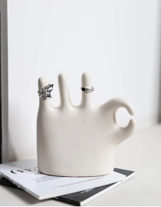 Detail of cream white ceramic OK hand jewelry display stand showing ring holders