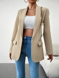 Détail d'un blazer beige avec une coupe professionnelle et deux poches à rabat fonctionnelles