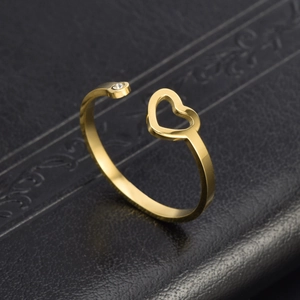 Adjustable gold heart ring featuring a cutout design and a small white diamond accent
