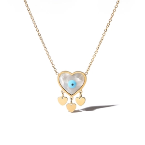 Detailed close-up of golden heart pendant with mother-of-pearl and blue evil eye charms