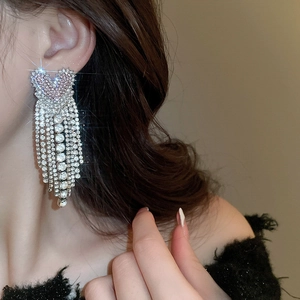 Detail of silver needle Ancora red heart tassel earrings with sparkling rhinestones for women
