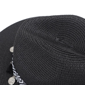 Close-up of woven straw fedora with ethnic black and white geometric band and tassels