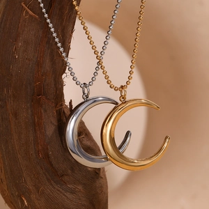 French moon pendant necklaces in gold and silver steel hanging on wood