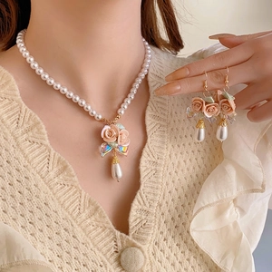 French ceramic floral necklace and pearl earrings set shown on model for elegant style