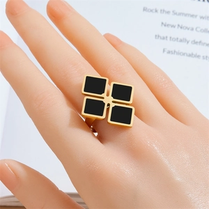 Minimalist gold stainless steel ring with black geometric squares worn on a model hand