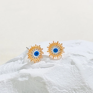 Detailansicht goldener Sonnen-Ohrstecker mit blauem Auge und funkelnden Kristallen