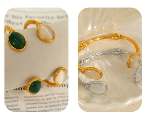 Detail of vintage open bangle with oval cat eye stones in gold and silver finish