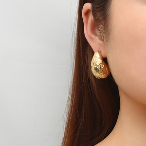 Boucles d'oreilles vintage dorées en forme de goutte avec motif cœur sur un mannequin